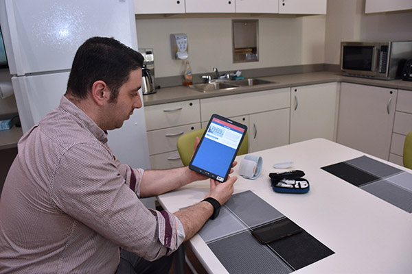 Man sitting at table holding tablet