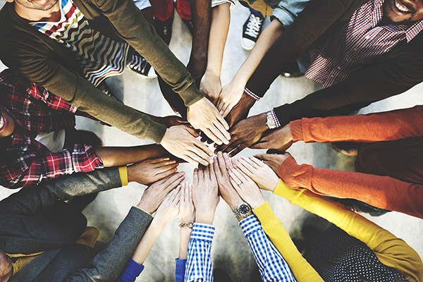 group of people with hands in the centre of the circle 