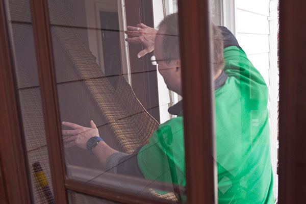 A man moving a piece of furniture through a doorway